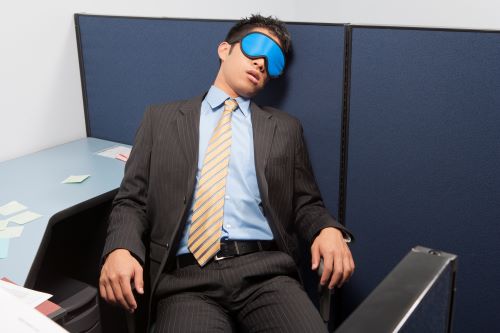 man sleeping in office cubicle