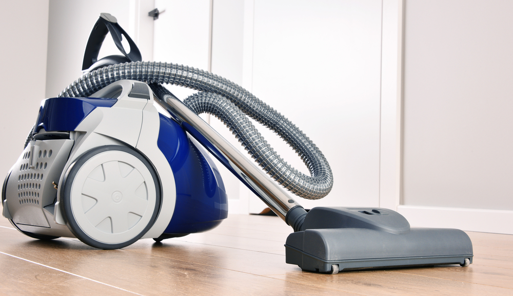 A quiet canister vacuum cleaner on a wood floor