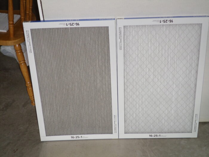 A used furnace air filter beside a new, unused filter