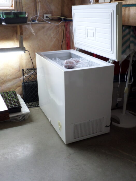 side view of chest freezer with lid open, showing vent on side
