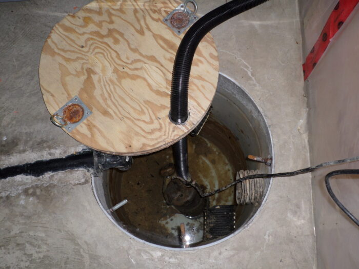 basement sump pump with cover removed and well exposed